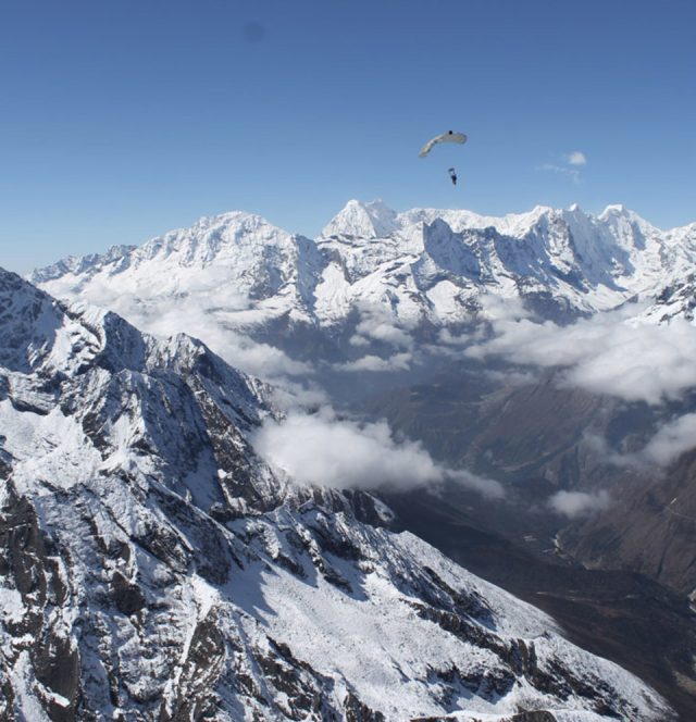 Skydiver flying CPS Special Operations Vector (SOV3-HH) Harness/Container System for HAHO/HALO over snowcapped mountains