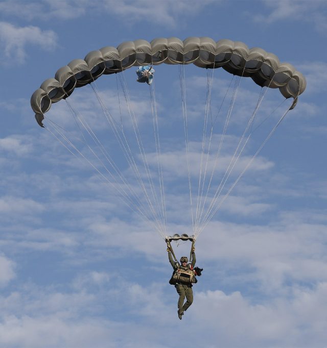 Jumper with K9 flying beneath the Military Phoenix parachute