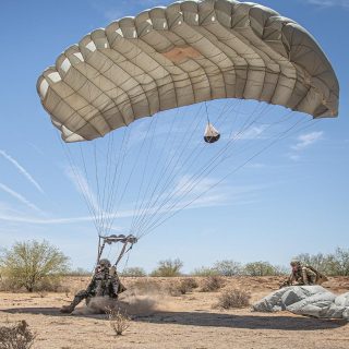 Military jumper landing Military Silhouette canopy in a desert region